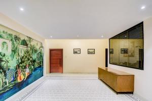 a hallway with a large painting on the wall at Townhouse Chandpole Metro Station Formerly Hotel Raghuraj Palace in Jaipur