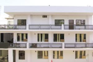 a white building with balconies on top of it at Srt rajput hotel Subhash Marg Charbhag Lucknow in Lucknow