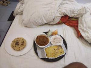 a breakfast plate of food on a bed at Srt rajput hotel Subhash Marg Charbhag Lucknow in Lucknow