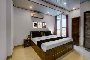 a bedroom with a bed and a window at Collection O Saral Bihari Temple Formerly Black Panther in Sheodāspura +22 photos