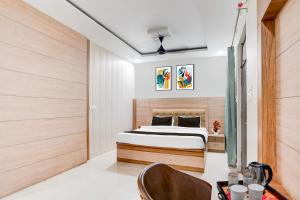 a bedroom with a bed and a table and a chair at OYO Hotel O Subedarganj Railway Junction Formerly Krishna Inn in Prayagraj