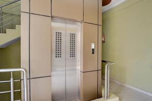 a glass elevator in a building with a staircase at OYO Hotel O Subedarganj Railway Junction Formerly Krishna Inn in Prayagraj