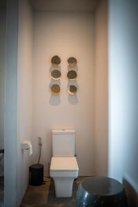 a bathroom with a toilet and two plates on the wall at Lusa Beach Studios Lovina in Lovina +8 photos