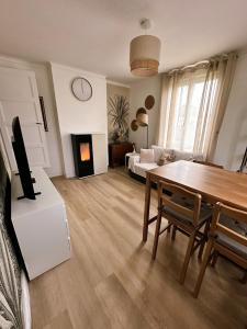 a living room with a dining room table and a couch at Charmante maison moderne et cosy in Aunay-sur-Odon