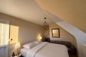 a bedroom with a white bed and a staircase at Charmante maison moderne et cosy in Aunay-sur-Odon