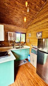 a large kitchen with wooden walls and wooden floors at Cabaña Colibrí - Parking in Sarchí