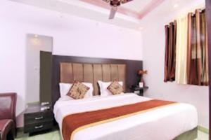 a bedroom with a large bed and a chair at Srt rajput hotel Subhash Marg Charbhag Lucknow in Lucknow
