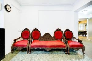 a red couch sitting in a living room at Super Collection O Holiday Street Calangute Formerly Shruti Resort in Goa