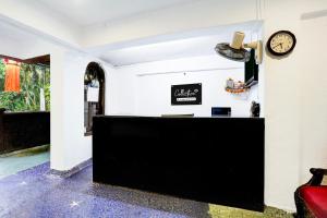 a black counter in a room with a clock on the wall at Super Collection O Holiday Street Calangute Formerly Shruti Resort in Goa