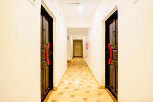 a hallway with two doors and a tile floor at Super Collection O Holiday Street Calangute Formerly Shruti Resort in Goa +46 photos