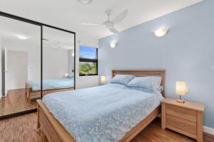 a bedroom with a large bed and a mirror at Sunsets on Kalang in Urunga