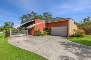 a red brick house with a garage at Sunsets on Kalang in Urunga