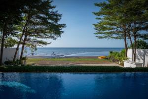 a swimming pool with the ocean in the background at Lusa Beach Studios Lovina in Lovina