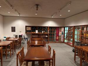 a dining room with wooden tables and chairs at ロッヂ 雪ん子 in Yuzawa