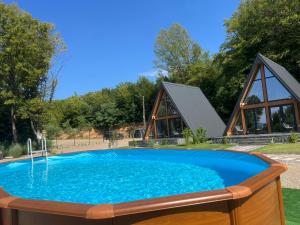a swimming pool with a house in the background at A-frame Marisa Vadu Crisului in Vadu Crişului