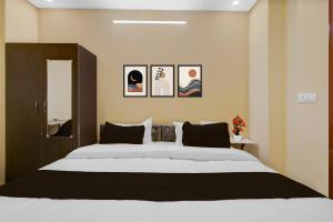 a bedroom with a large bed with four pictures on the wall at Hotel O Deva Road Lucknow Formerly Awadh Regency in Lucknow +22 photos