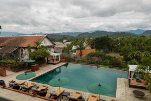a swimming pool with chairs and umbrellas at La Résidence Phou Vao in Luang Prabang