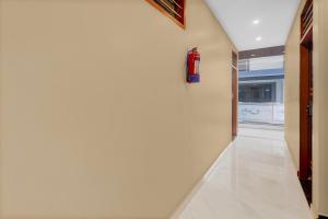 a hallway with a fire extinguisher on the wall at Hotel O Deva Road Lucknow Formerly Awadh Regency in Lucknow