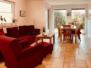 a living room with a red couch and a table at Ferienhaus Inselliebe in Vieregge