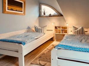 a bedroom with two beds and a window at Ferienhaus Inselliebe in Vieregge
