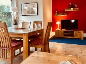 a dining room with a table and a television at Ferienhaus Inselliebe in Vieregge
