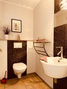a bathroom with a white toilet and a sink at Ferienhaus Inselliebe in Vieregge +21 photos