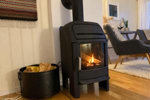 a wood stove in a living room with a bucket at A pearl in Lofoten in Leknes +35 photos
