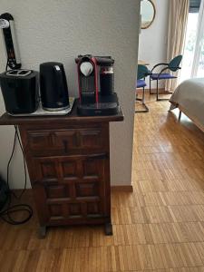 a wooden dresser with a camera on top of it at Grande chambre avec Salle de Bains Privative in Lausanne