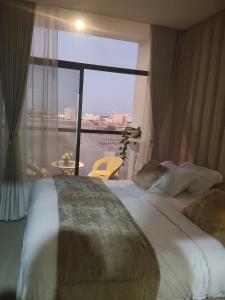 a bedroom with a large bed and a large window at Alaziba view in ‘Udhaybah +20 photos