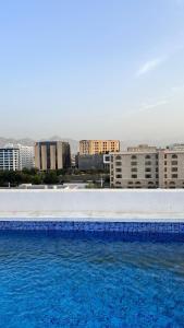 a large swimming pool with buildings in the background at Alaziba view in ‘Udhaybah