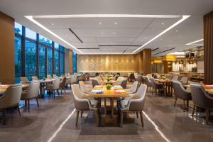 a restaurant with tables and chairs and windows at Wyndham Shanghai Pudong in Shanghai