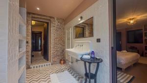 a bathroom with a sink and a bed in a room at Charmante maison de ville avec vue sur le donjon avec wifi et jardin in Gouffern en Auge +33 photos