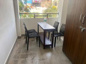 a table and chairs in a room with a window at Eiffel Pondy in Pondicherry +5 photos