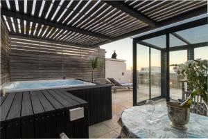 a jacuzzi tub on a patio with a table at Namaste in Cape Town