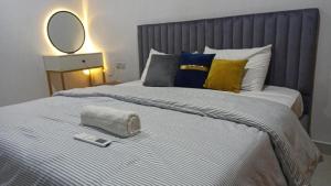a bedroom with a bed with a mirror and a remote control at Delight 1 Bedroom Apartment - Off Awolowo Road Ikeja in Ikeja