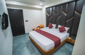 a bedroom with a large bed with red pillows at Hotel The Avanta - Gandhinagar in Gandhinagar +27 photos