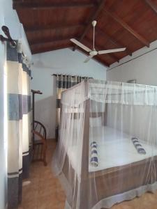 a bedroom with a bed with a mosquito net at 39 House Weligama in Weligama