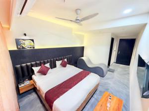 a bedroom with a large bed with red pillows at Hotel The Avanta - Gandhinagar in Gandhinagar