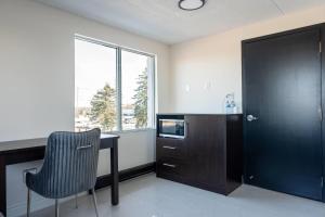 a kitchen with a desk and a chair and a window at Howard Johnson by Wyndham Brampton in Brampton +21 photos