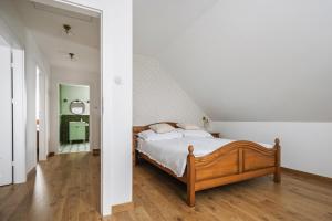 a bedroom with a bed with white walls and wooden floors at Domek w Jacni in Jacnia