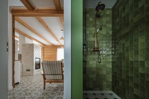 a bathroom with a shower with green tiles at Domek w Jacni in Jacnia +47 photos
