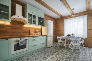 a kitchen with a table and a white refrigerator at Domek w Jacni in Jacnia