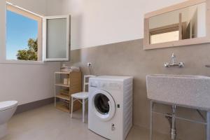 Un baño con lavadora y lavabo. en Villa Rosalore' by Perle di Puglia, en Ugento