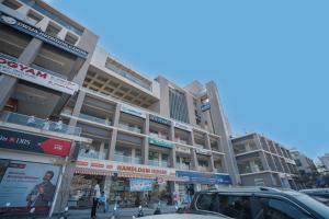 a tall building with cars parked in front of it at Hotel The Avanta - Gandhinagar in Gandhinagar