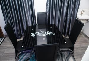 a black table with black chairs and a table with a skull on it at Shepherd Spring Apartments in Gbogije