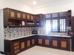 a kitchen with wooden cabinets and a counter top at Hill House Rest in Mirissa +41 photos