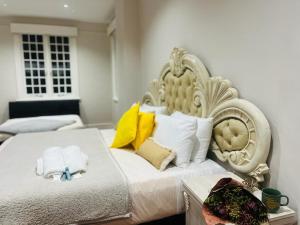 a bedroom with a large white bed with yellow pillows at HEBA GUEST LODGE in Uitenhage