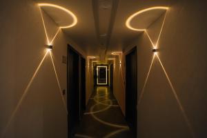 a long hallway with lights on the walls at Hotel The Avanta - Gandhinagar in Gandhinagar
