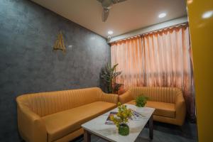 a living room with two couches and a table at Hotel The Avanta - Gandhinagar in Gandhinagar