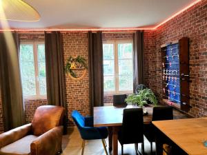 a dining room with a brick wall and a table and chairs at L atelier des jeux in Beauvais +11 photos